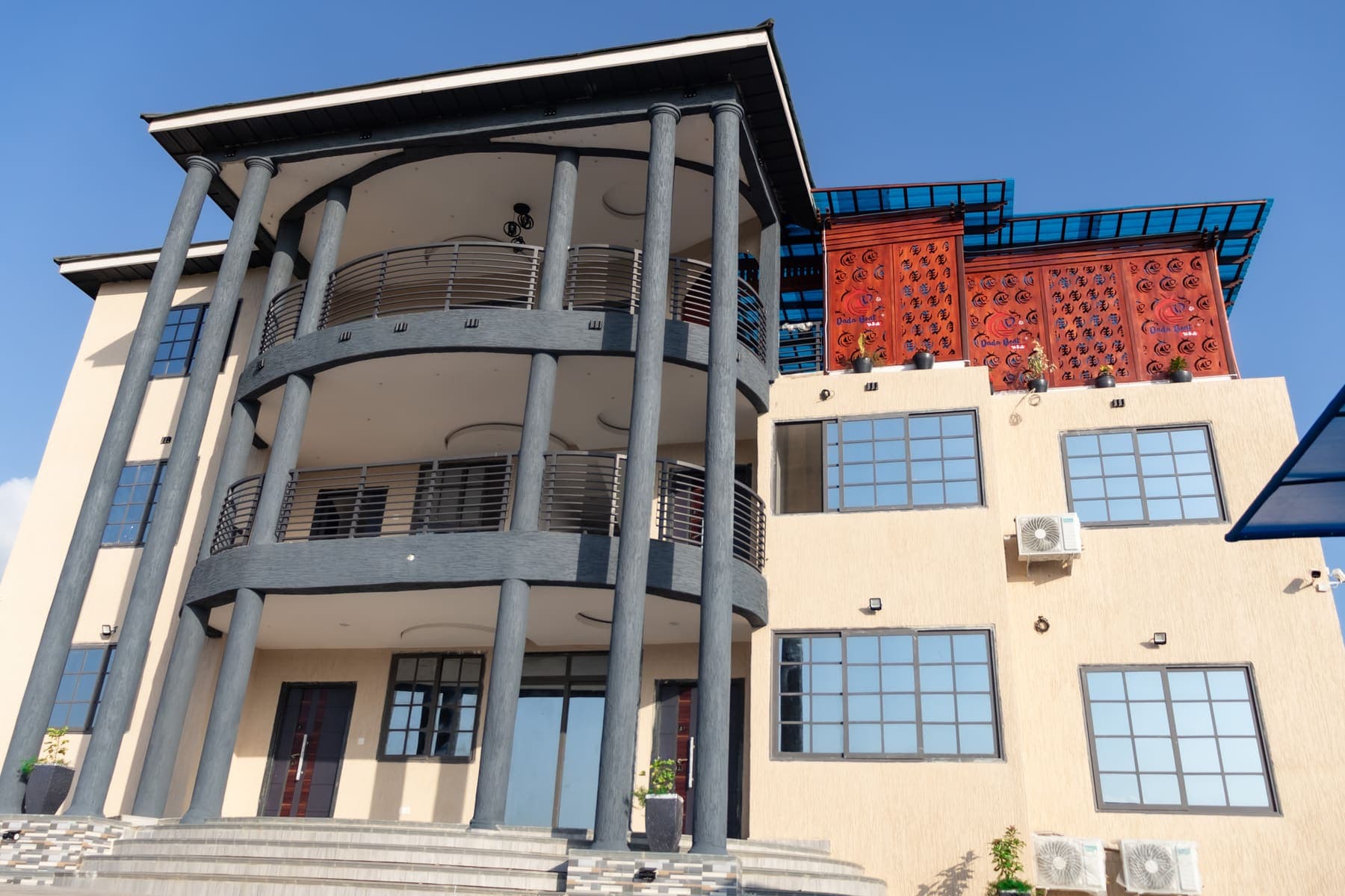 The front steps up to the DeHideout building, under its curved balconies