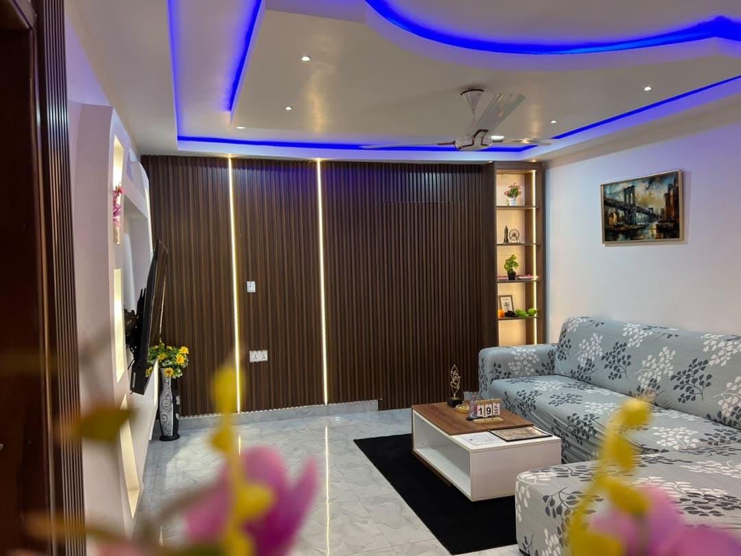 Unit 3 lounge after dark, lit by blue ceiling lights and its fluted timber wall